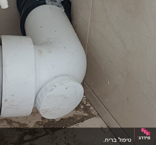 צנרת לבנה עם חיבורים על רצפה מלוכלכת